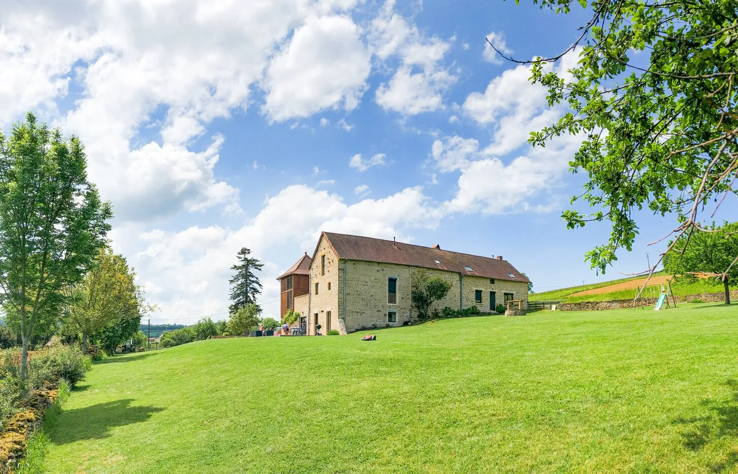 La maison au bout de la pelouse, sous un ciel de nuages