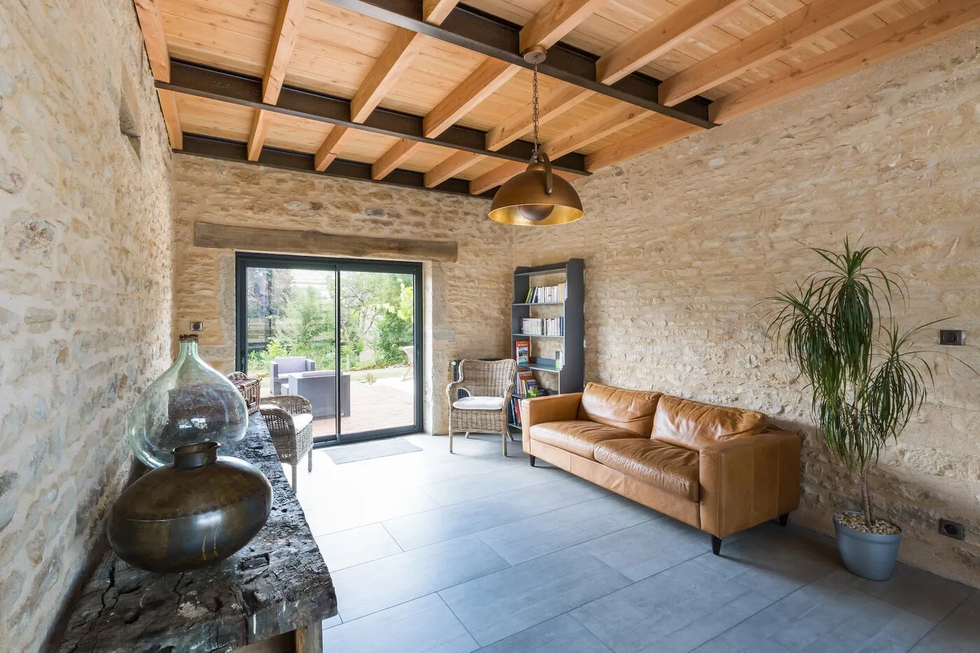 Le salon, murs en pierre et canapé en cuir